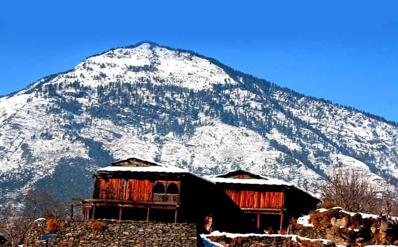 snow-clapped mountains featuring slop mounted houses and snow everywhere in Naggar village