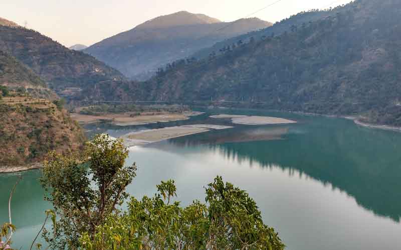 The pandoh dam and lake surrounds the mountains hills long tree and lush greenery environment.